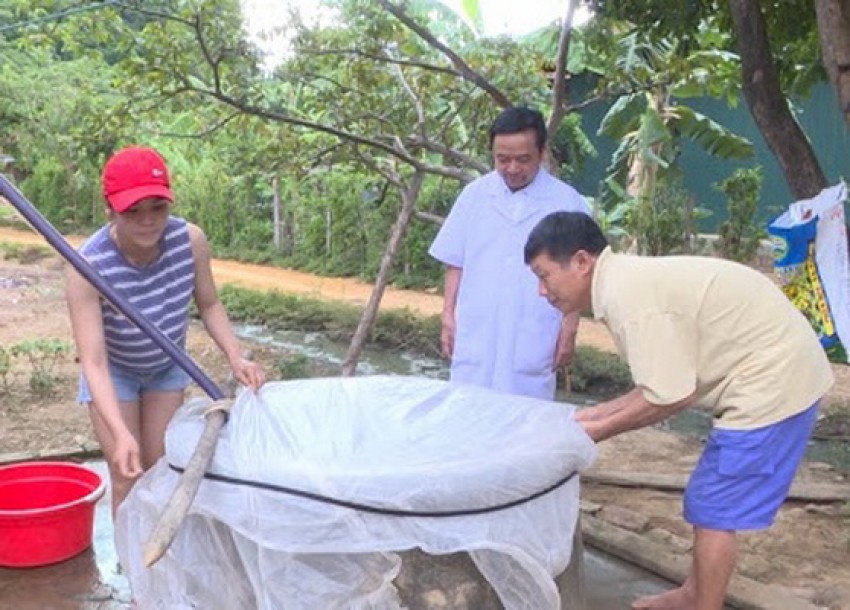 Cán bộ y tế hướng dẫn người dân cách bảo vệ nguồn nước khi mưa lũ xảy ra.